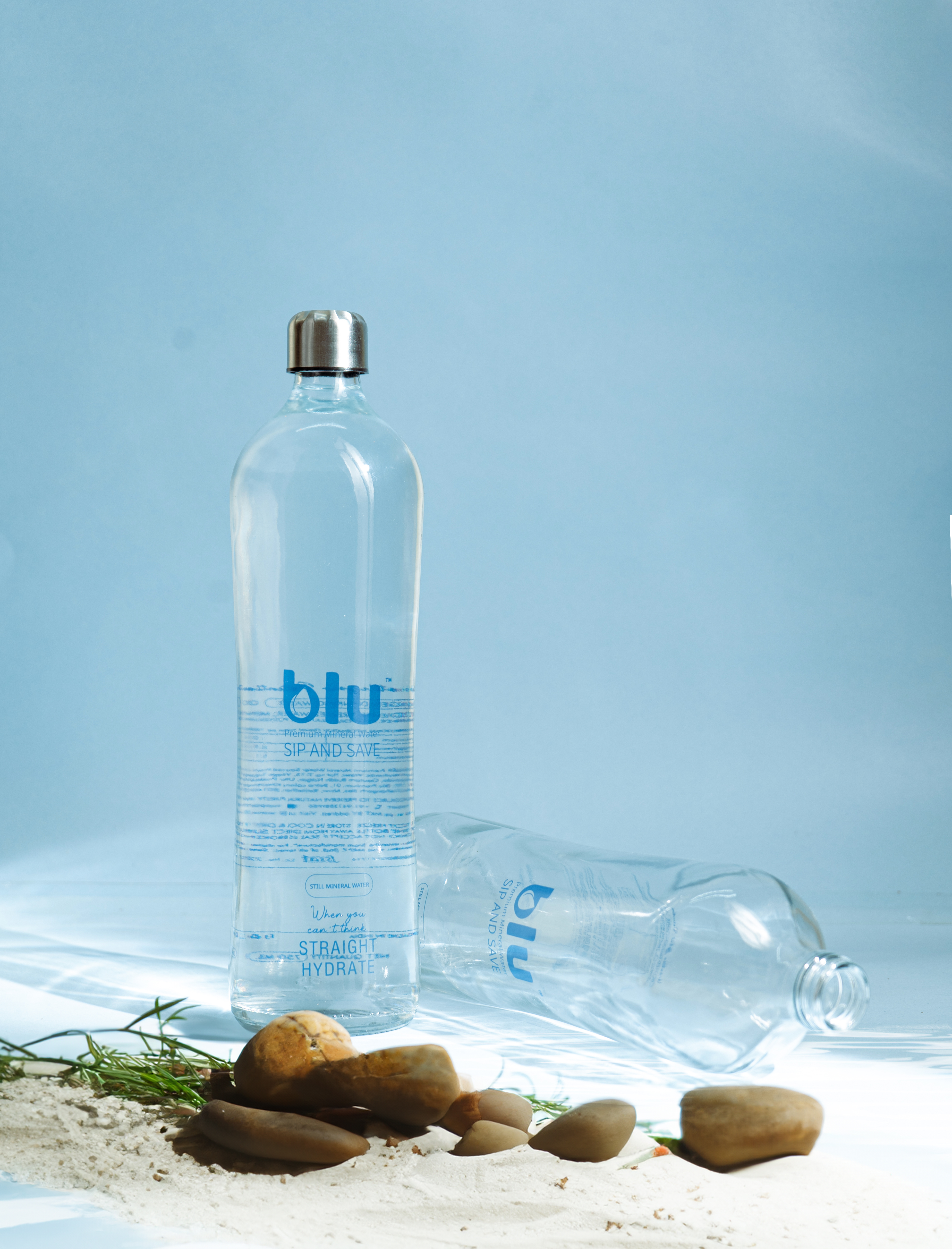 Two Blu Premium bottles on sandy beach